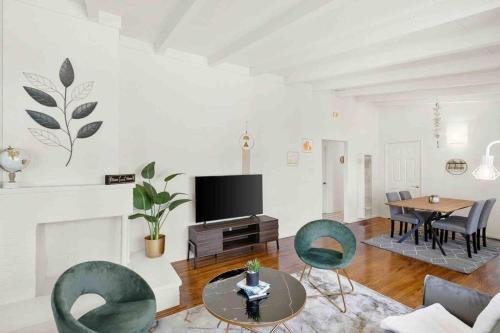 a living room with a tv and a table and chairs at Mid Century Garden View Home Parking in San Mateo
