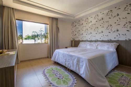 1 dormitorio con cama blanca y ventana en Vila com 4 Casas ao mar de Cotovelo por Carpediem, en Parnamirim