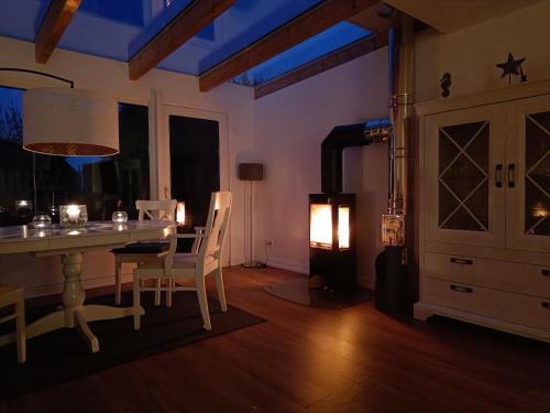 a dining room with a table and chairs and a stove at Beachhouse mit privater Sauna und Kamin, 700m zum Strand in Schönberger Strand