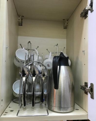a kitchen shelf with utensils and a tea kettle at Maliaways Comfy Airbnb-Jkia in Nairobi