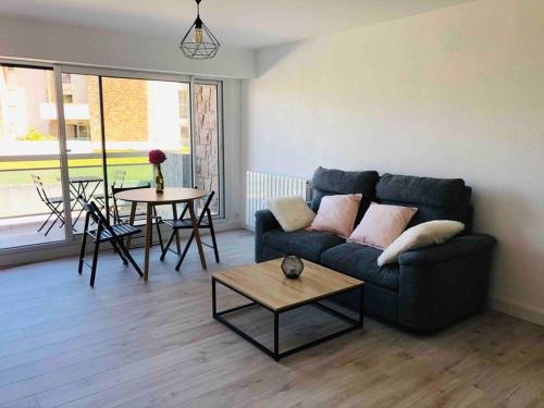 un salon avec un canapé et une table dans l'établissement Grand studio 43m2 port de Perros Guirec, à Perros-Guirec