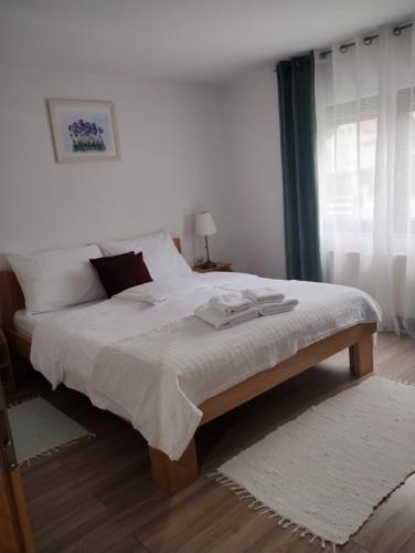 a bedroom with a large bed with two towels on it at House Leonarda in Grabovac