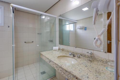 La salle de bains est pourvue d'un lavabo et d'une douche. dans l'établissement Quality Hotel Jundiaí, à Jundiaí