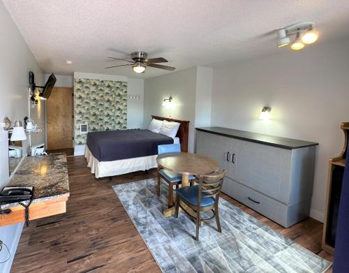 Schlafzimmer mit einem Bett, einem Tisch und Stühlen in der Unterkunft Myrtle Lane Inn in Coquille