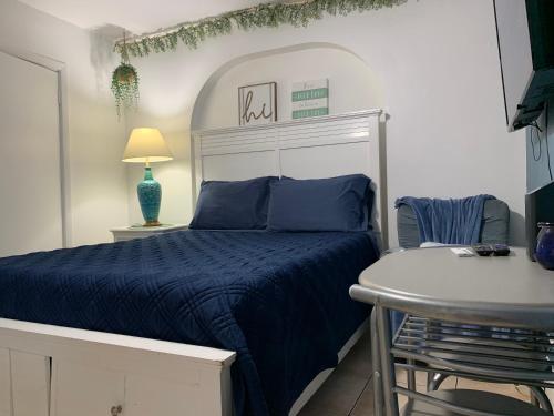 a bedroom with a blue bed and a table at Mini Studio: 10 min/Siesta Key/Private entrance/ in Sarasota