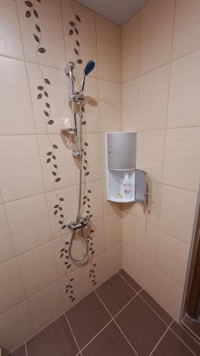 a shower in a tiled bathroom with a shower head at Studio Demokratsia in Burgas City