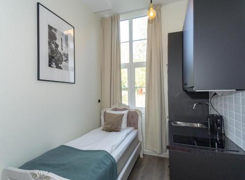 Cette petite chambre comprend un lit et une fenêtre. dans l'établissement Déus Longstay, à Rosersberg