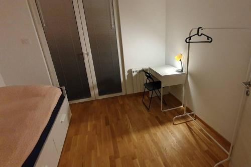 a bedroom with a bed and a desk with a lamp at Skopje home 5 in Skopje