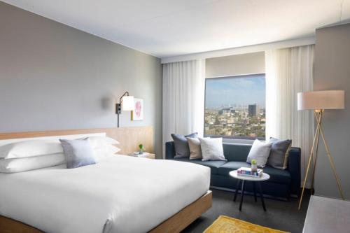 une chambre d'hôtel avec un lit et un canapé dans l'établissement Kimpton Everly Hotel Hollywood, an IHG Hotel, à Los Angeles