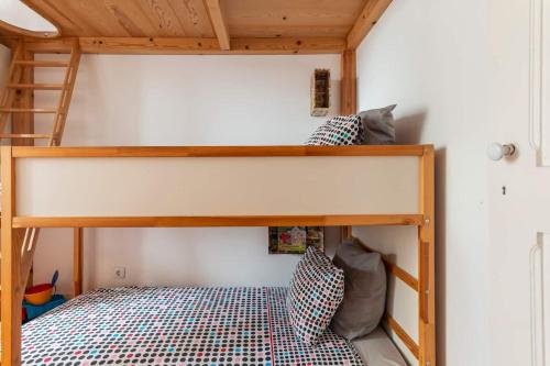 een slaapkamer met een stapelbed en een ladder bij Say What Lisbon? — Street Art / Family Apartment in Lissabon
