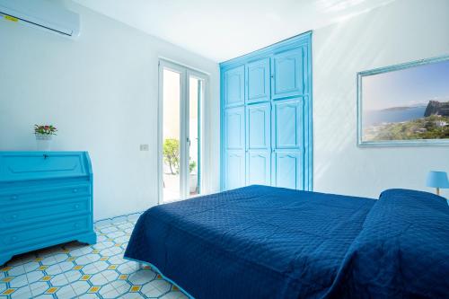 ein Schlafzimmer mit einem blauen Bett und einer blauen Kommode in der Unterkunft La Baia Blu - Ischia in Ischia
