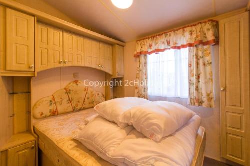 ハンスタントンにある6 Berth Dog Friendly Caravan In Hunstanton, Minutes From The Beach Ref 13013lのベッドルーム1室(枕付きのベッド1台、窓付)