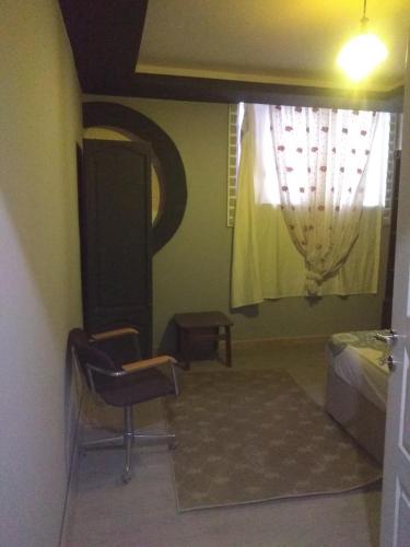 1 dormitorio con cama, ventana y silla en mediterranean house en Antalya