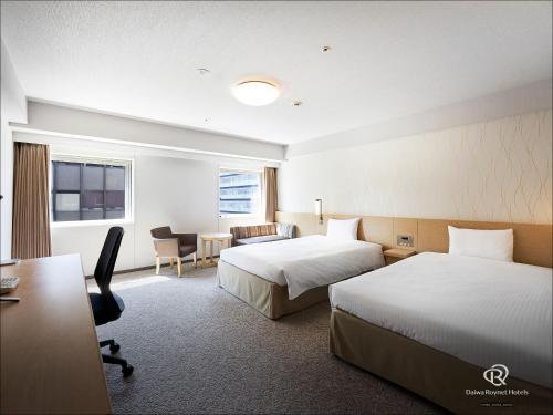 a hotel room with two beds and a desk at Daiwa Roynet Hotel Yokohama Kannai in Yokohama