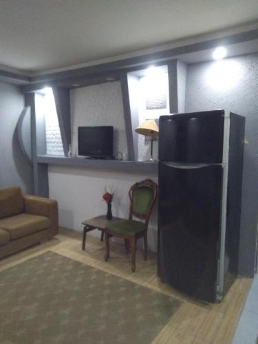 uma sala de estar com um frigorífico preto e uma cadeira em mediterranean house em Antalya