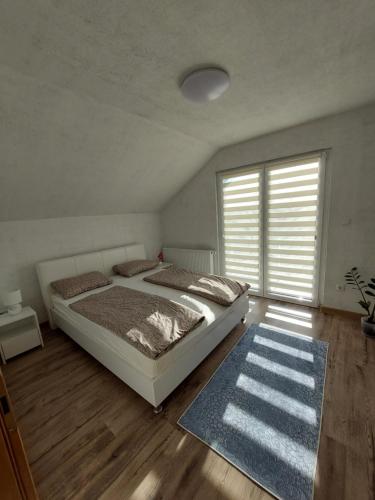 a bedroom with a bed and a large window at Apartman Halilčević in Dubrave Gornje