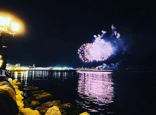 a fire show in the sky over the water at night at ARCO MERAVIGLIA HOUSE in Bari