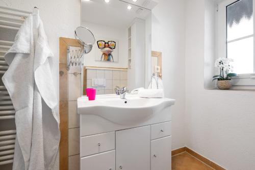 a white bathroom with a sink and a mirror at Zum Fährmann 2 Whg 1 EG links in 18356 Pruchten in Pruchten