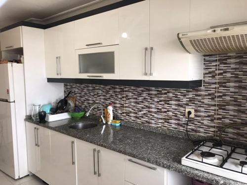 uma cozinha com armários brancos e um lavatório em Golden horn view apartment 2 em Istambul