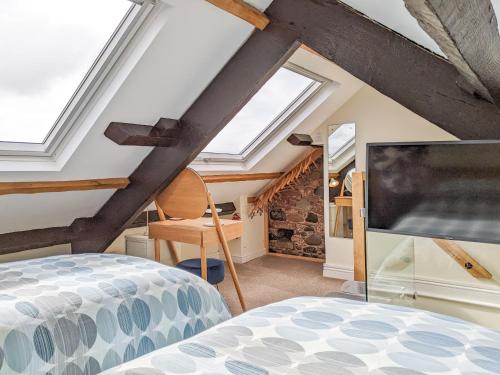a living room with a large tv in a attic at Seascape Cottage in Allonby