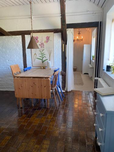 a dining room with a wooden table and chairs at Hyggelig ferielejlighed v/ Blokhus in Pandrup