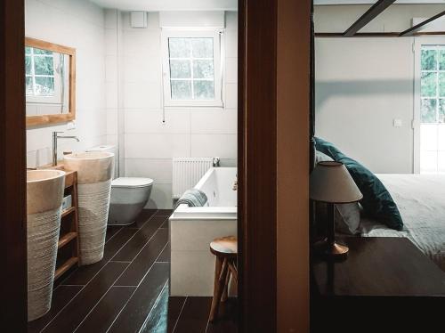 a bathroom with a tub and a sink and a bed at Casa Cosy in Serra