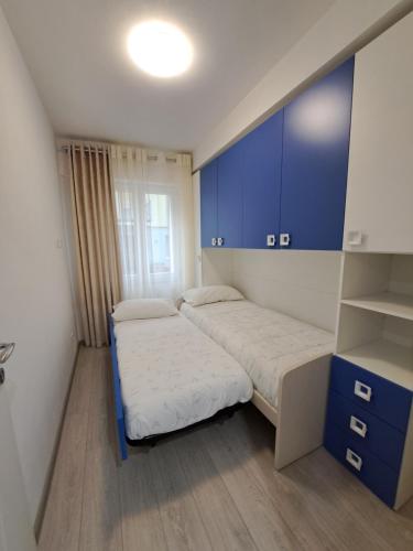 Kleines Zimmer mit 2 Betten und blauen Schränken in der Unterkunft Bellariva in Riva del Garda