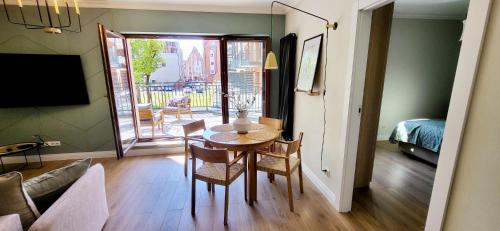 a room with a table and chairs and a bedroom at Komfortowy Apartament Przy Bramie Targowej - Old Town in Elblag