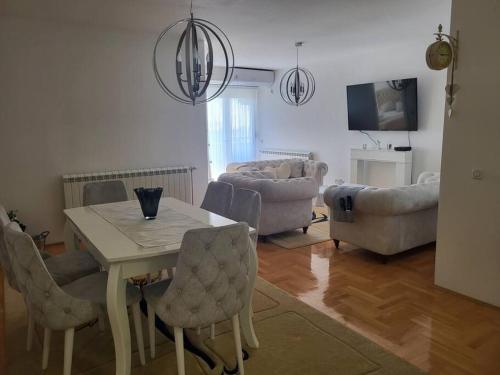 a living room with a table and chairs and a couch at Luxury Central Apartment in Strumica