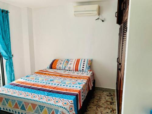 a bedroom with a bed with a quilt on it at Apartment for 8, near to the beache and downtown in Cartagena de Indias