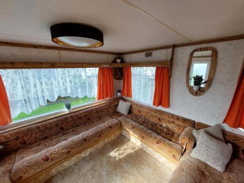 a couch in a room with a large window at Idyllic Family Holiday Caravan in Skegness