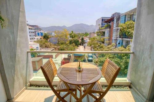 a table and chairs on a balcony with a view at 2 bd Loft in Versalles, Walk to the Beach! in Puerto Vallarta