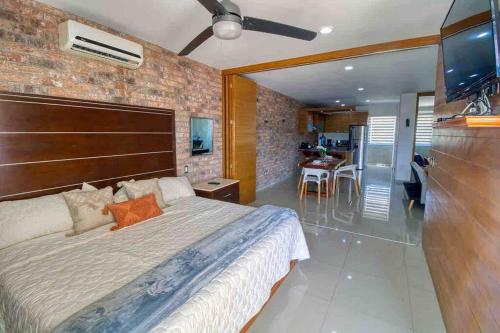a bedroom with a large bed and a kitchen at 2 bd Loft in Versalles, Walk to the Beach! in Puerto Vallarta
