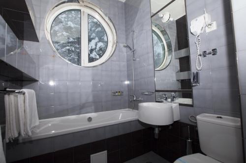 a bathroom with a tub and a toilet and a sink at Family Hotel Saint George in Sofia