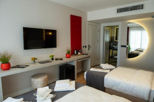 Habitación de hotel con 2 camas y TV de pantalla plana. en Linda Port Hotel, en Estambul