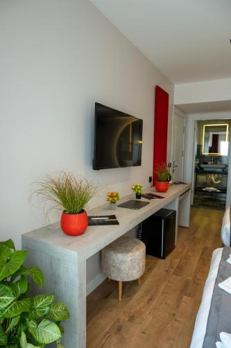 a living room with a desk with a tv on the wall at Linda Port Hotel in Istanbul