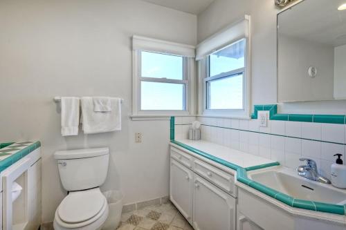 a white bathroom with a toilet and a sink at Villa Jules, Oceanfront, Private Beach, Fire Pit in Oceanside