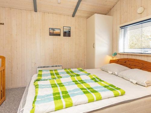 1 dormitorio con 1 cama grande y edredón a rayas en Three-Bedroom Holiday home in Øster Assels 1 en Sillerslev