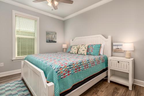 a bedroom with a bed and a ceiling fan at Sunny & 75 in Dauphin Island