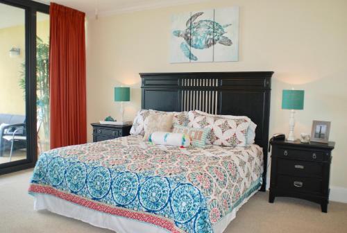 a bedroom with a bed and two night stands with lamps at Holiday Isle 107 in Dauphin Island