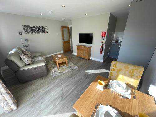 a living room with a couch and a television at Crich Lane Farm in Alfreton
