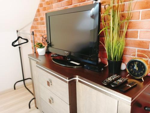 einen Fernseher auf einer Kommode mit Ziegelwand in der Unterkunft Apartament na Glinkach 22 in Augustów