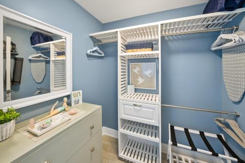 um closet com paredes azuis e prateleiras brancas em Calypso 3 Luxury Beach Vacation Sleeps 8 em Panama City Beach