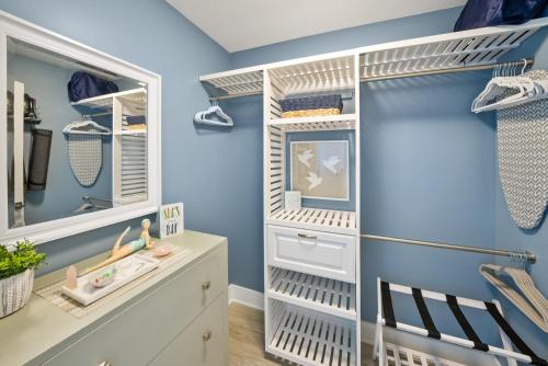a walk in closet with blue walls and white shelving at Calypso 3 Luxury Beach Vacation Sleeps 8 in Panama City Beach