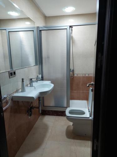 een badkamer met een toilet, een wastafel en een douche bij Residence La corniche Étage 2 in Nador