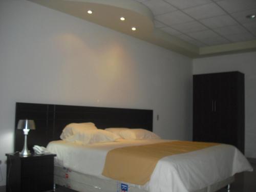 Ένα ή περισσότερα κρεβάτια σε δωμάτιο στο La Estancia Hotel