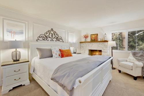 a white bedroom with a bed and a fireplace at Soaring Pines by Big Bear Vacations Central Cozy Estate Chalet in Big Bear Lake