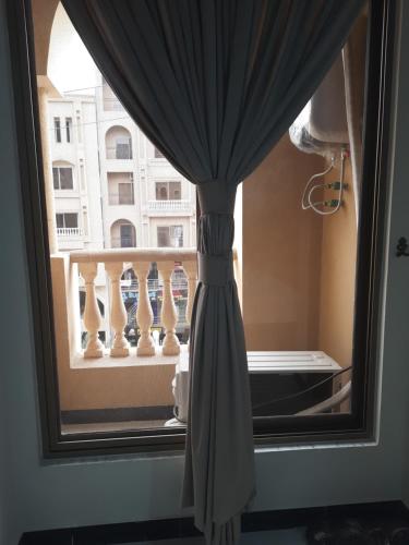 a curtain in a window with a view of a building at Northern Suites Bahria town in Rawalpindi