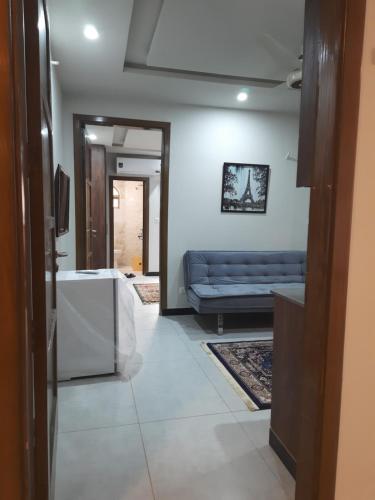 a living room with a blue couch in a room at Northern Suites Bahria town in Rawalpindi