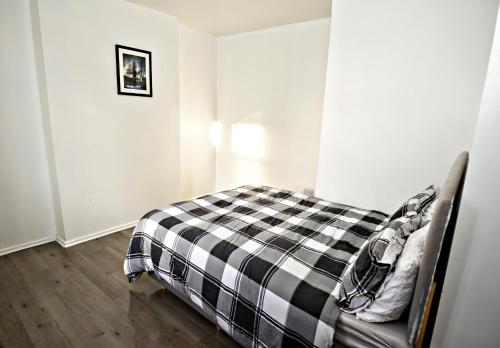 a bedroom with a bed with a checkered blanket at AG HOUSE in Manchester